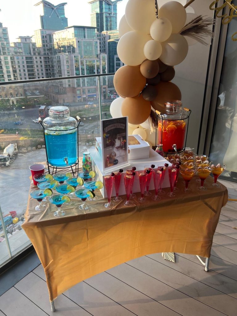 Colorful cocktail station with blue, pink, and orange drinks