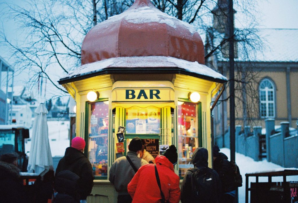 People are gathered at a small outdoor bar.