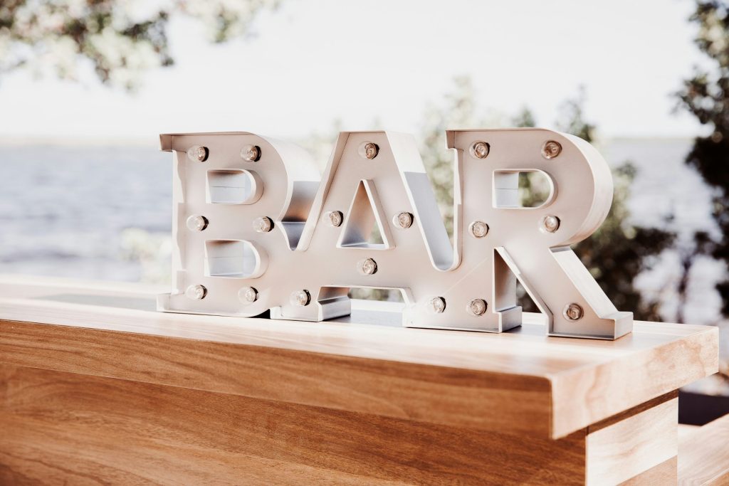 a bar sign sitting on top of a wooden table